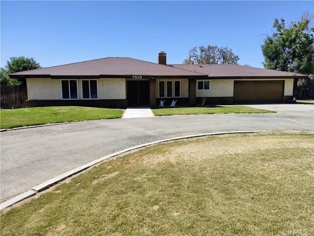 7519 Man O War St, Bakersfield, CA 93307 - ranch-style home with stucco siding, driveway, a chimney, and an attached garage