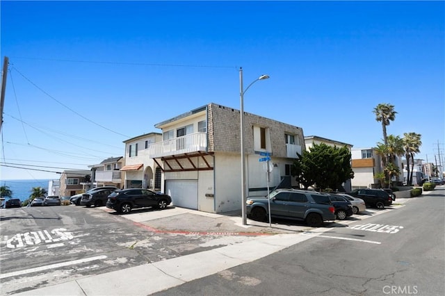 330 34th Pl, Manhattan Beach, CA 90266 - view of front of property with mansard roof, a shingled roof, an attached garage, stucco siding, and a balcony