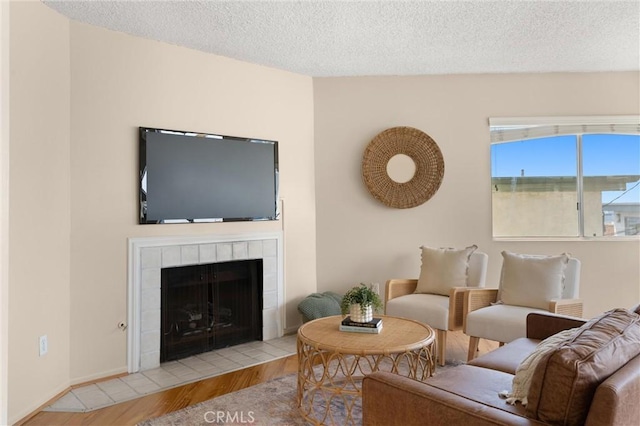 330 34th Pl, Manhattan Beach, CA 90266 - living room featuring wood finished floors, a tiled fireplace, and a textured ceiling