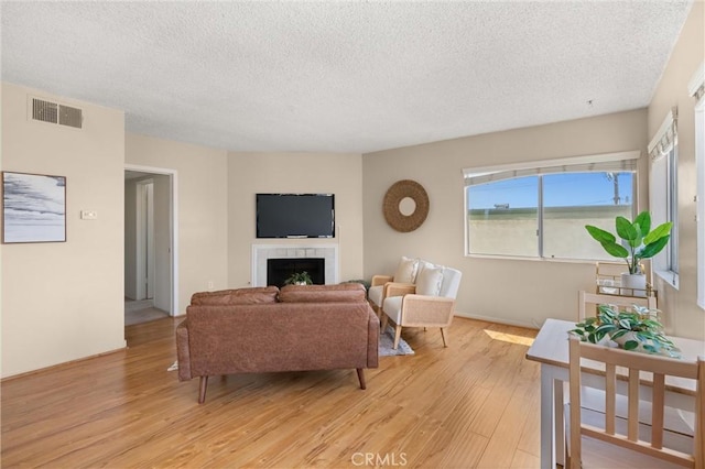 330 34th Pl, Manhattan Beach, CA 90266 - living area featuring light wood-type flooring, a textured ceiling, and a fireplace
