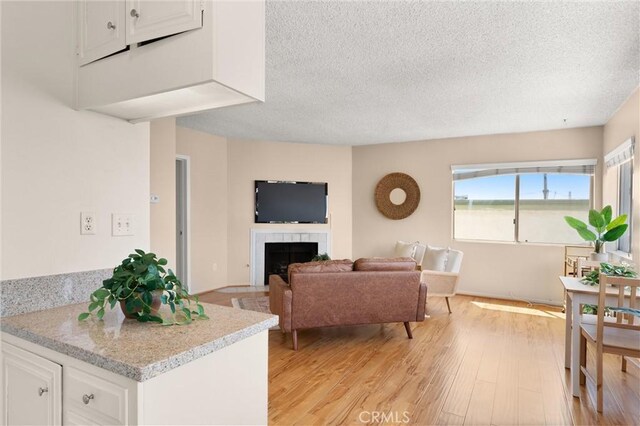330 34th Pl, Manhattan Beach, CA 90266 - living room with a textured ceiling, light wood-style floors, and a fireplace
