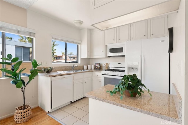 330 34th Pl, Manhattan Beach, CA 90266 - kitchen with white appliances, light stone counters, light wood-style flooring, and white cabinetry