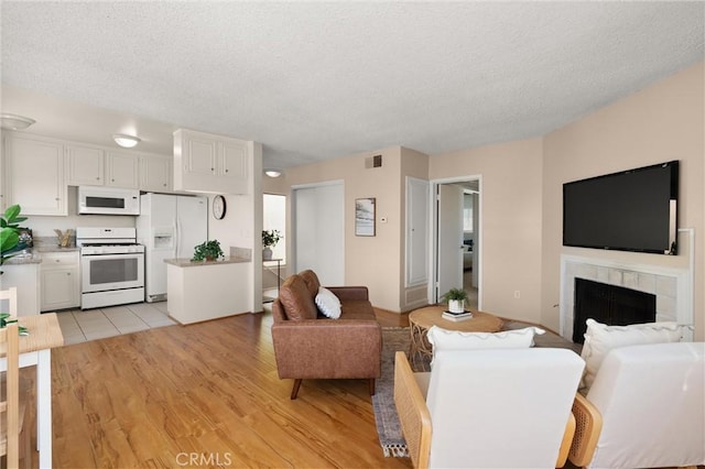 330 34th Pl, Manhattan Beach, CA 90266 - living room with a textured ceiling, a tile fireplace, and light wood finished floors