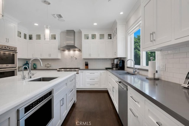 15460 La Maida St, Sherman Oaks, CA 91403 - kitchen with appliances with stainless steel finishes, wall chimney range hood, backsplash, white cabinetry, and recessed lighting