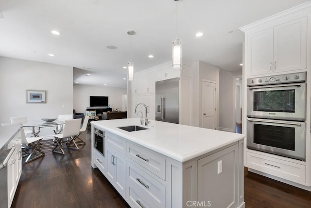 15460 La Maida St, Sherman Oaks, CA 91403 - kitchen featuring appliances with stainless steel finishes, dark wood finished floors, white cabinetry, decorative light fixtures, and light countertops