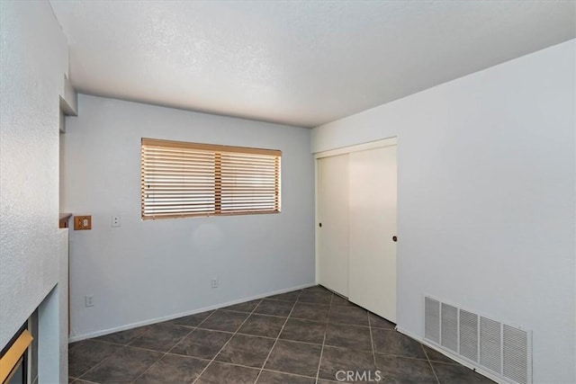 10151 Saddlehill Ter, Rancho Cucamonga, CA 91737 - unfurnished bedroom featuring a closet and dark tile patterned floors