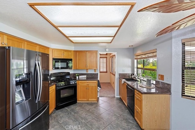 10151 Saddlehill Ter, Rancho Cucamonga, CA 91737 - kitchen featuring black appliances, dark countertops, a textured ceiling, and dark tile patterned floors