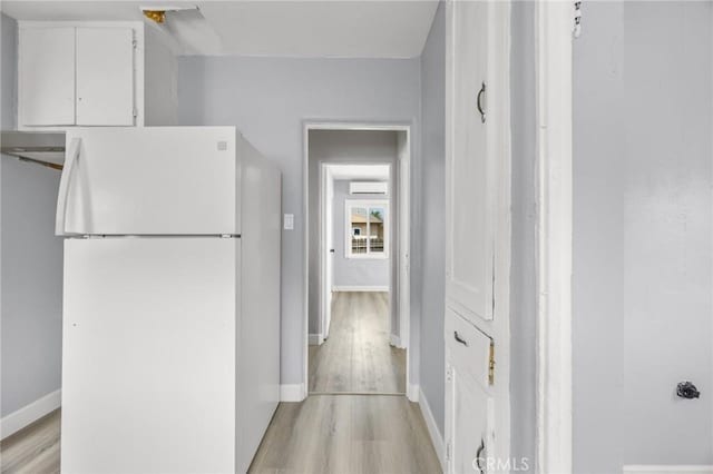 1163 W 3rd St, Pomona, CA 91766 - hallway with light wood-style floors and a wall mounted AC