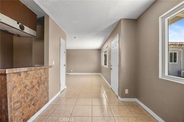 1163 W 3rd St, Pomona, CA 91766 - hall featuring plenty of natural light, light tile patterned floors, and a textured ceiling