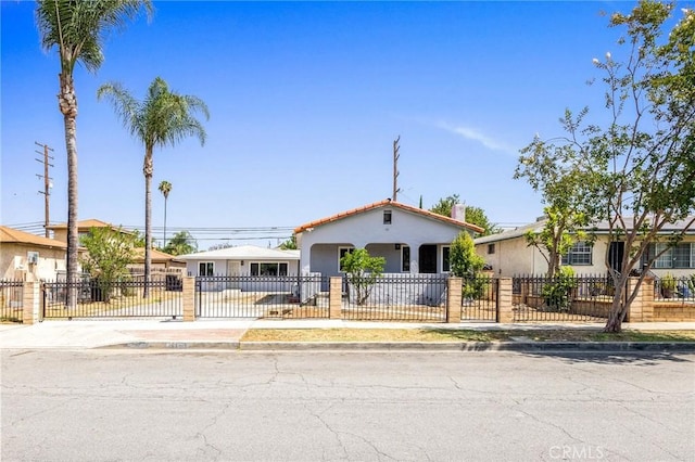 1163 W 3rd St, Pomona, CA 91766 - view of front of house with stucco siding, a fenced front yard, and concrete driveway