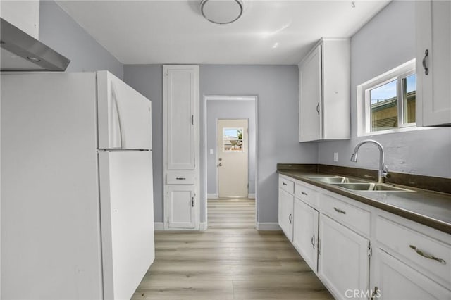 1163 W 3rd St, Pomona, CA 91766 - kitchen with freestanding refrigerator, wall chimney range hood, dark countertops, and healthy amount of natural light