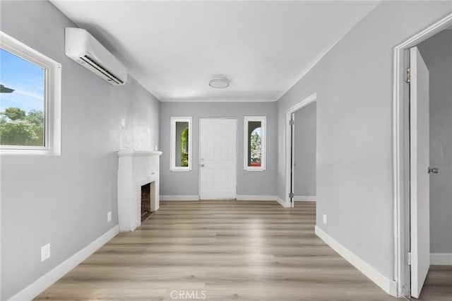 1163 W 3rd St, Pomona, CA 91766 - entryway featuring an AC wall unit, a fireplace, and light wood-type flooring