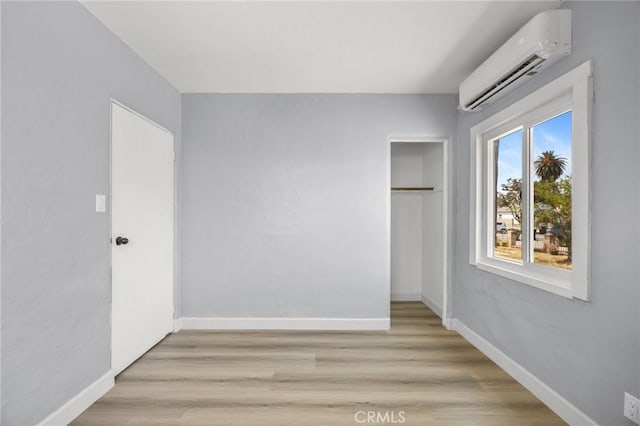 1163 W 3rd St, Pomona, CA 91766 - unfurnished bedroom featuring a wall mounted air conditioner, a closet, and light wood-type flooring