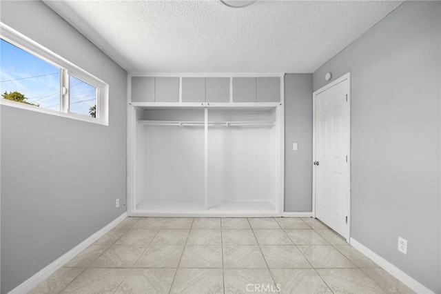 1163 W 3rd St, Pomona, CA 91766 - unfurnished bedroom with a textured ceiling and a closet