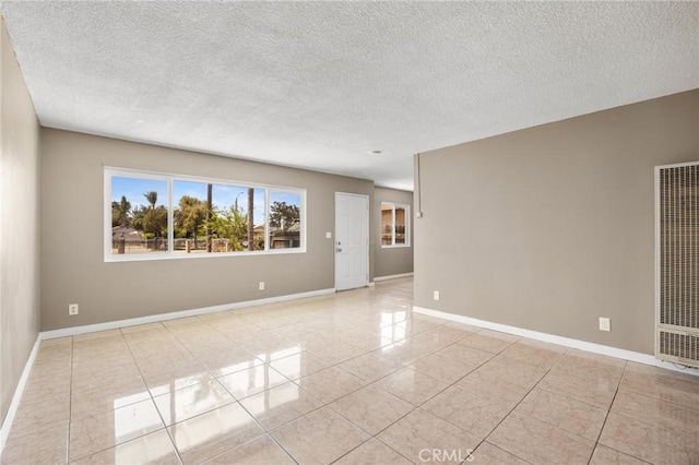 1163 W 3rd St, Pomona, CA 91766 - empty room with a heating unit, light tile patterned floors, and a textured ceiling