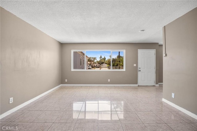 1163 W 3rd St, Pomona, CA 91766 - empty room with a textured ceiling and light tile patterned flooring