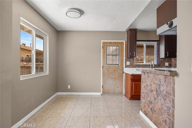 1163 W 3rd St, Pomona, CA 91766 - kitchen featuring a textured ceiling, light tile patterned flooring, and decorative backsplash