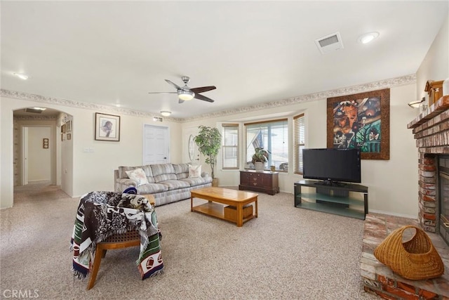 21276 White Pine Dr, Tehachapi, CA 93561 - carpeted living area with arched walkways, a ceiling fan, and a fireplace