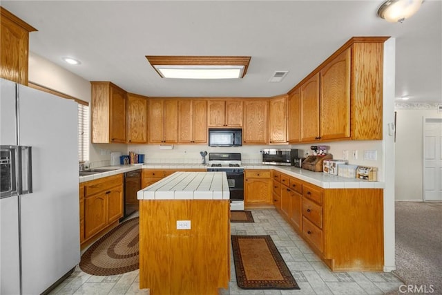 21276 White Pine Dr, Tehachapi, CA 93561 - kitchen with black appliances, a center island, tile counters, and brown cabinetry