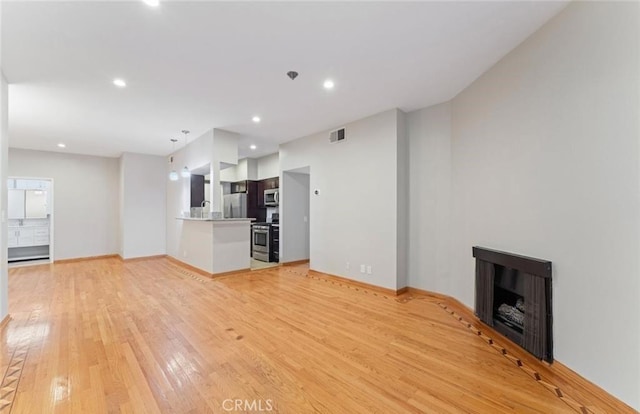4705 Kester Ave Unit 209, Sherman Oaks, CA 91403 - unfurnished living room featuring light wood-type flooring, a fireplace, and recessed lighting