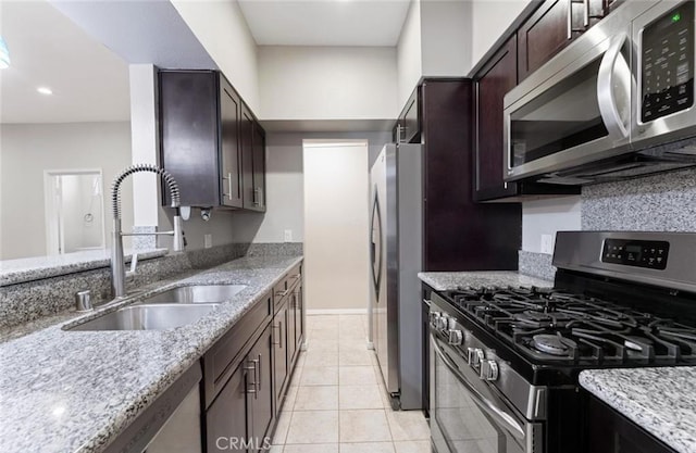 4705 Kester Ave Unit 209, Sherman Oaks, CA 91403 - kitchen with stainless steel appliances, light stone countertops, dark brown cabinetry, recessed lighting, and light tile patterned flooring