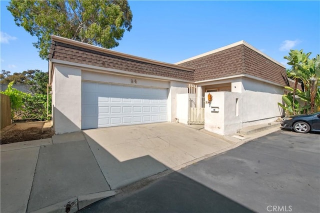 24 Queens Wreath Way, Irvine, CA 92612 - front facade with mansard roof, a shingled roof, stucco siding, concrete driveway, and a garage