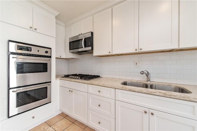 24 Queens Wreath Way, Irvine, CA 92612 - kitchen with appliances with stainless steel finishes, white cabinetry, light tile patterned flooring, light stone counters, and ornamental molding