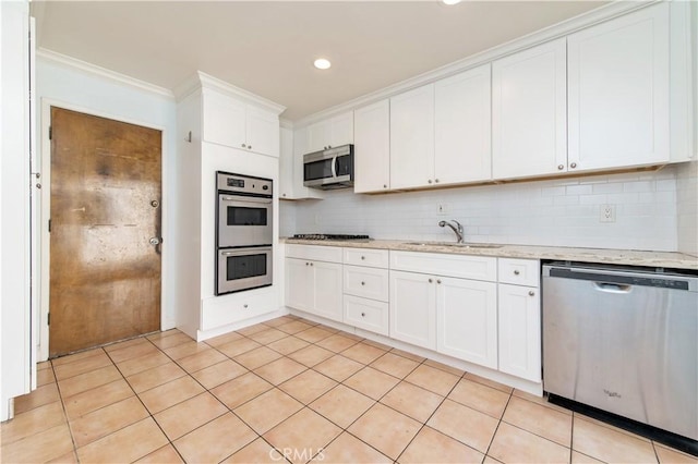 24 Queens Wreath Way, Irvine, CA 92612 - kitchen with appliances with stainless steel finishes, backsplash, white cabinetry, ornamental molding, and recessed lighting