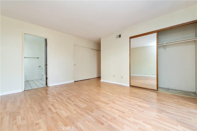 24 Queens Wreath Way, Irvine, CA 92612 - unfurnished bedroom featuring two closets, light wood finished floors, and ensuite bath