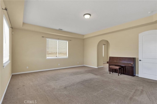 21777 Poppy Rd, Apple Valley, CA 92308 - empty room featuring arched walkways, carpet, and plenty of natural light