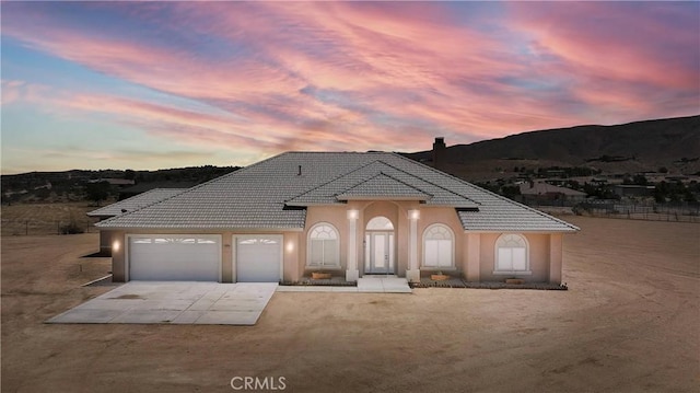 21777 Poppy Rd, Apple Valley, CA 92308 - view of front facade featuring a garage, driveway, a tile roof, a mountain view, and stucco siding