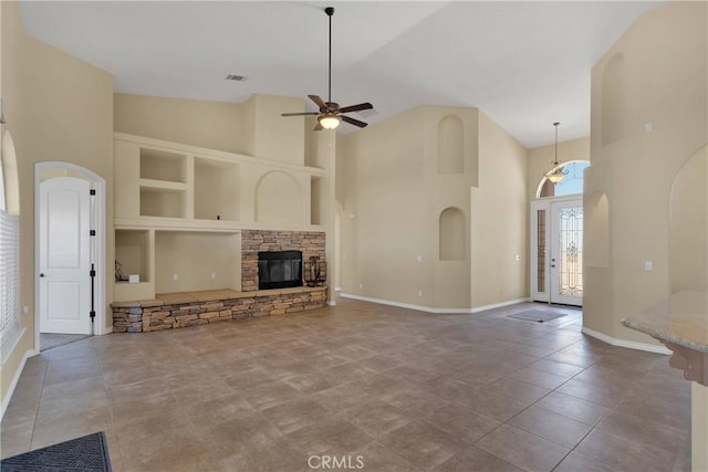 21777 Poppy Rd, Apple Valley, CA 92308 - unfurnished living room featuring high vaulted ceiling, a ceiling fan, arched walkways, built in features, and a stone fireplace