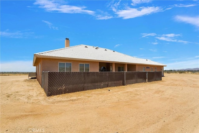 21777 Poppy Rd, Apple Valley, CA 92308 - back of house featuring a chimney, a tile roof, and stucco siding