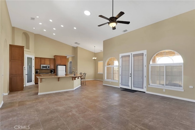 21777 Poppy Rd, Apple Valley, CA 92308 - kitchen with stainless steel microwave, freestanding refrigerator, high vaulted ceiling, a ceiling fan, and light countertops