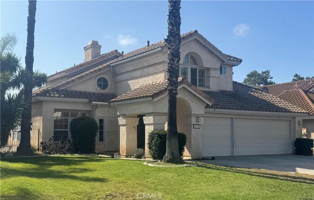 8932 Mesa Oak Dr, Riverside, CA 92508 - view of front of home with stucco siding, a front lawn, and driveway