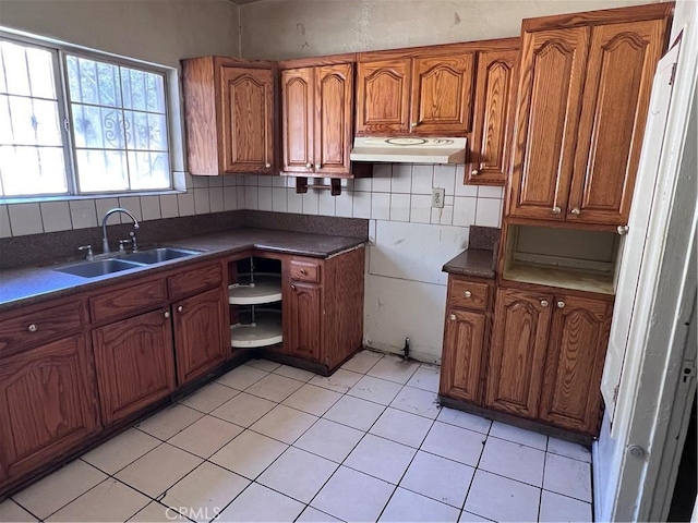 1086 N Bonnie Beach Pl, Los Angeles, CA 90063 - kitchen with under cabinet range hood, brown cabinets, dark countertops, and decorative backsplash