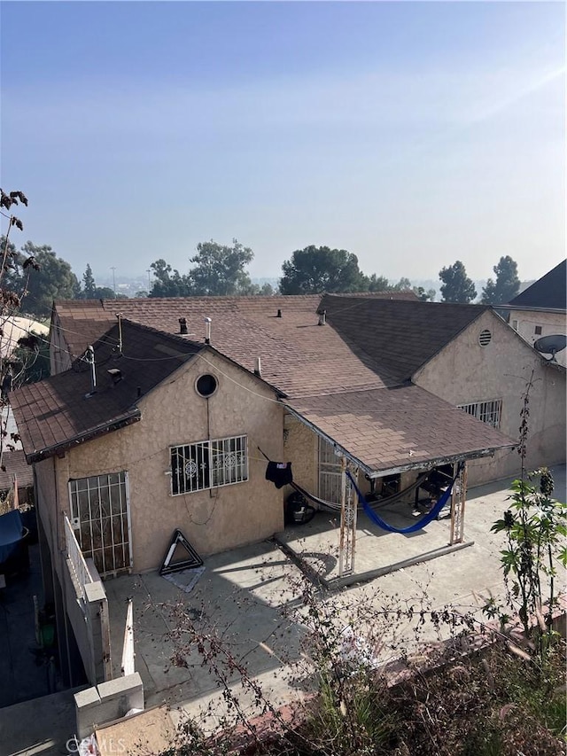 1086 N Bonnie Beach Pl, Los Angeles, CA 90063 - rear view of house featuring a patio area, roof with shingles, and stucco siding
