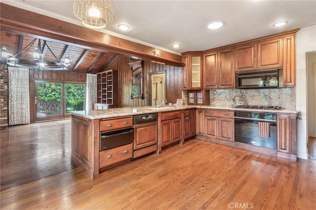2322 W 156th St, Gardena, CA 90249 - kitchen with black appliances, brown cabinetry, a peninsula, light stone counters, and decorative backsplash