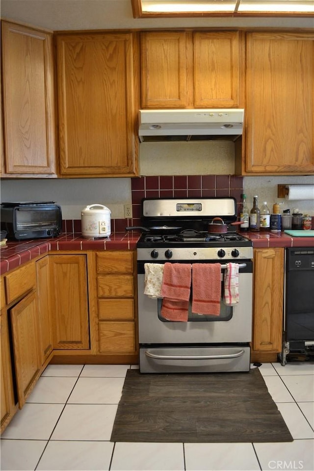 31811 Whispering Palms Trl, Cathedral City, CA 92234 - kitchen featuring gas range, tile countertops, under cabinet range hood, and light tile patterned flooring