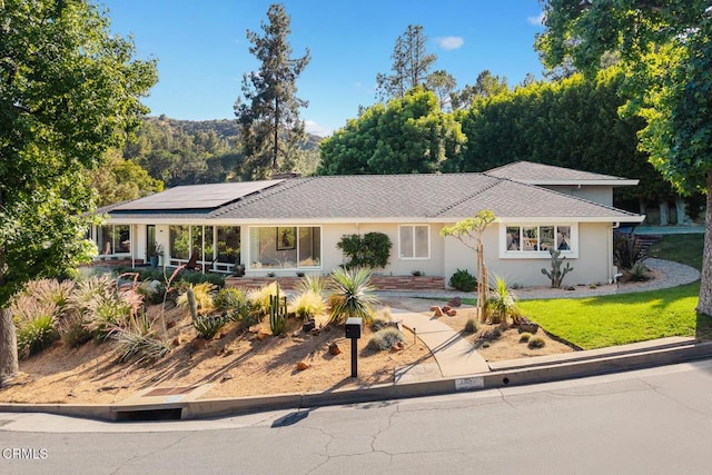 1620 Knollwood Dr, Pasadena, CA 91103 - single story home with roof mounted solar panels, stucco siding, and a front lawn