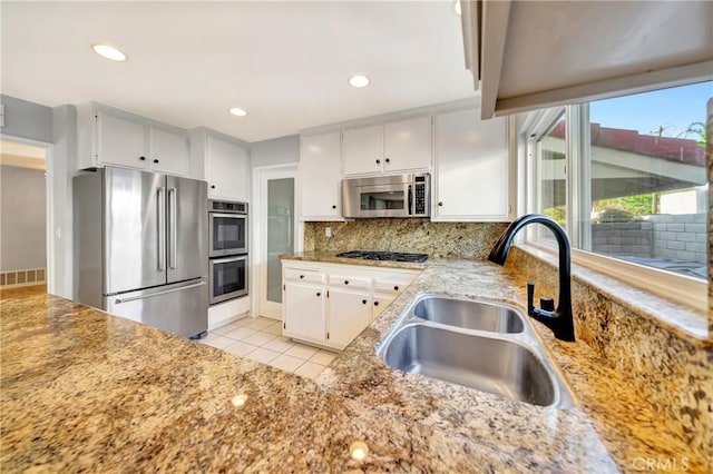 3811 Algonaut Dr, Calabasas, CA 91302 - kitchen featuring stainless steel appliances, tasteful backsplash, white cabinetry, light stone counters, and light tile patterned floors