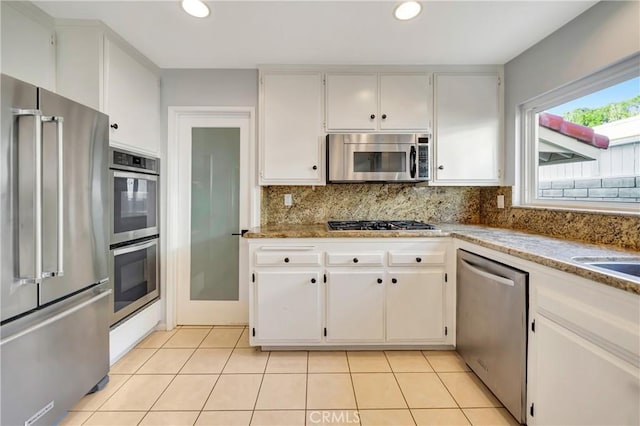 3811 Algonaut Dr, Calabasas, CA 91302 - kitchen featuring appliances with stainless steel finishes, decorative backsplash, light tile patterned floors, recessed lighting, and white cabinetry