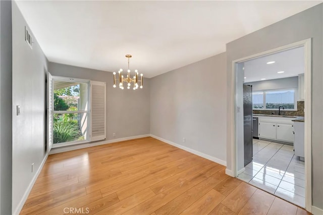 3811 Algonaut Dr, Calabasas, CA 91302 - empty room with a chandelier, healthy amount of natural light, and light wood-style flooring