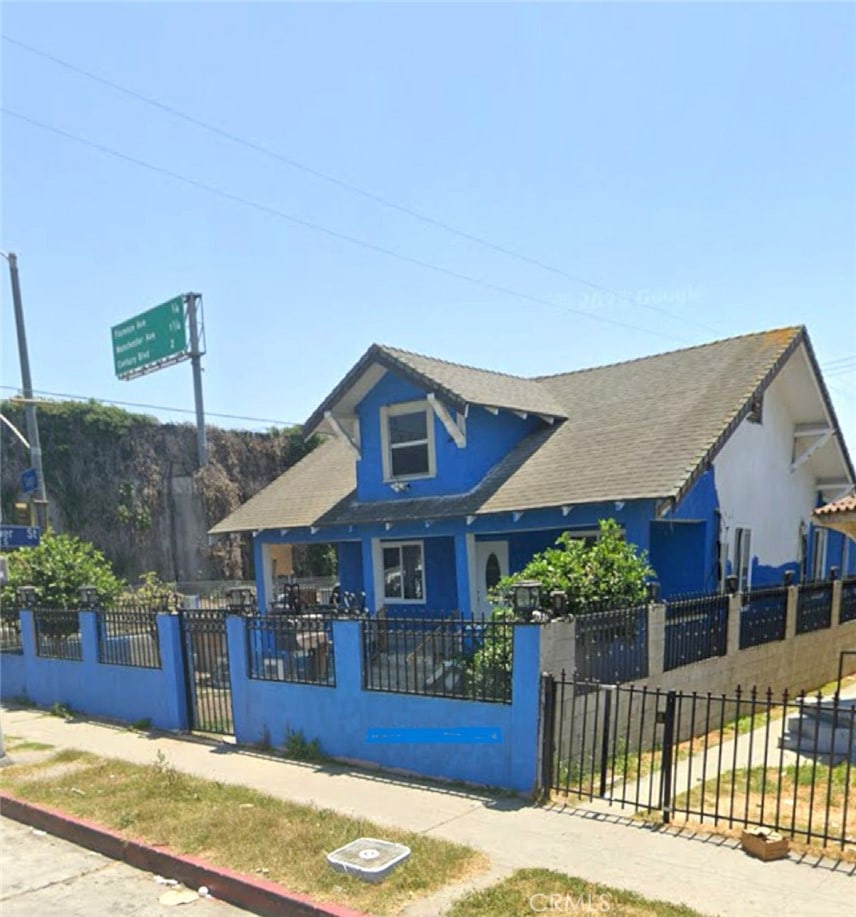 420 W Gage Ave, Los Angeles, CA 90003 - bungalow-style home with a fenced front yard, stucco siding, roof with shingles, and a gate