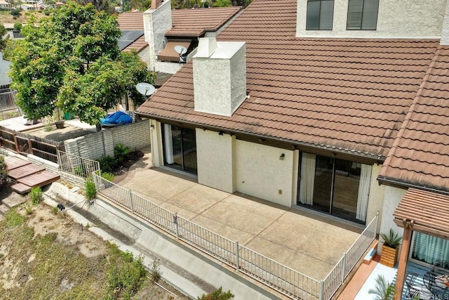 2315 Nicklaus Dr, Oceanside, CA 92056 - back of house featuring a tile roof, stucco siding, and a chimney