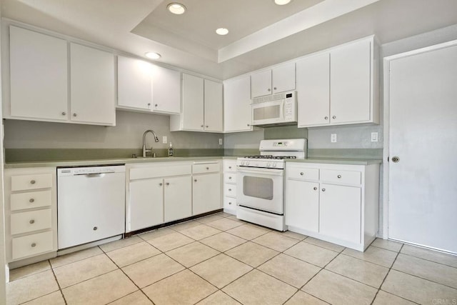 2315 Nicklaus Dr, Oceanside, CA 92056 - kitchen featuring white appliances, white cabinetry, recessed lighting, a raised ceiling, and light countertops