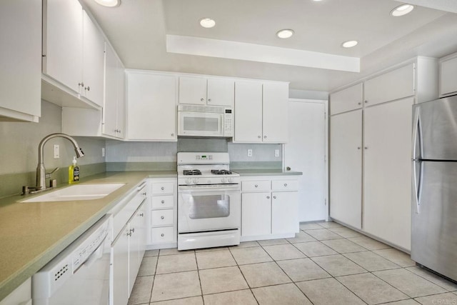 2315 Nicklaus Dr, Oceanside, CA 92056 - kitchen featuring white appliances, a tray ceiling, light countertops, white cabinets, and light tile patterned floors