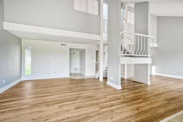 2315 Nicklaus Dr, Oceanside, CA 92056 - unfurnished living room with stairway, wood finished floors, and a high ceiling