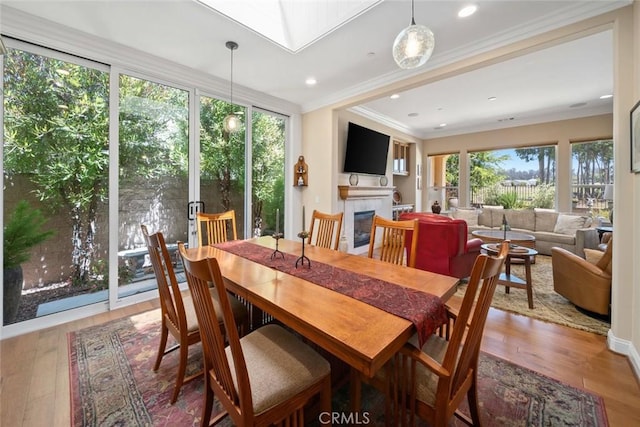 1432 Vicki Ln, Nipomo, CA 93444 - dining area featuring hardwood / wood-style flooring, a glass covered fireplace, ornamental molding, a skylight, and recessed lighting