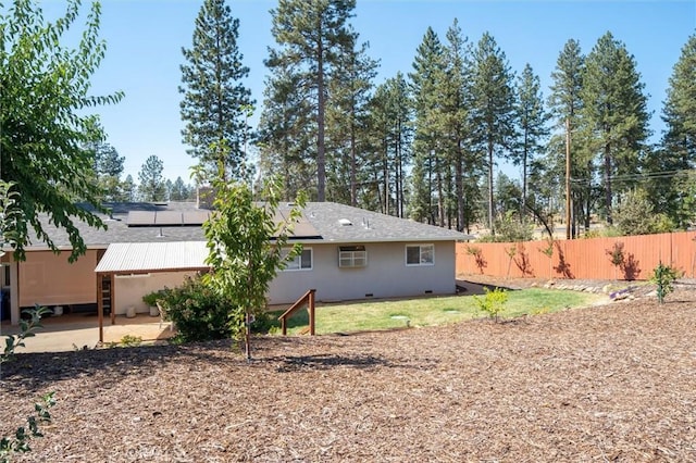 6354 Berkshire Ave, Paradise, CA 95969 - rear view of house with roof mounted solar panels, a patio area, a wall unit AC, and a shingled roof